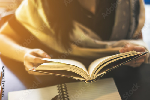 Young woman reading a book at the coffee shop