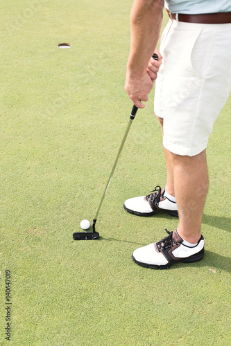 Low section of man playing golf at course