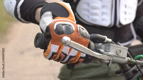 The motorcyclist is trying to start his motorcycle in the yard. photo