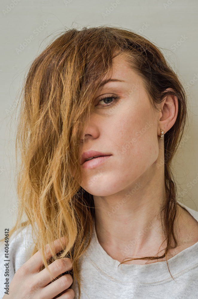 The face of a young girl covered with long hair The face of a young girl covered with long hair