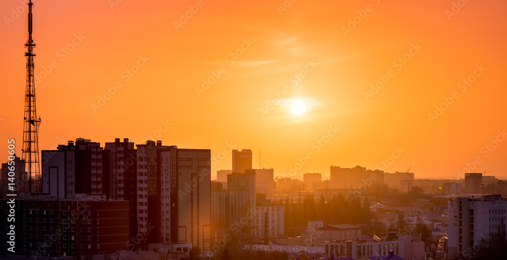 City in sunset time, Silhouettes of houses in the evening haze and the rays of t