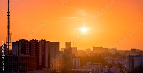City in sunset time, Silhouettes of houses in the evening haze and the rays of t