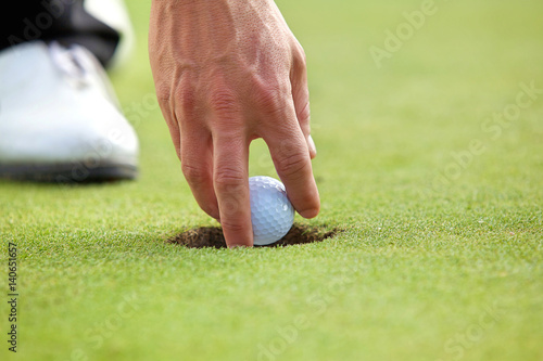 Person holding golf ball, close-up