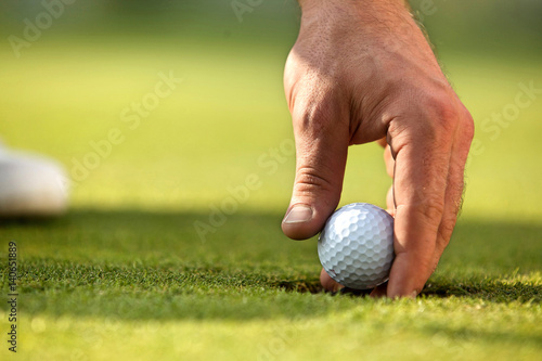 Person holding golf ball, close-up