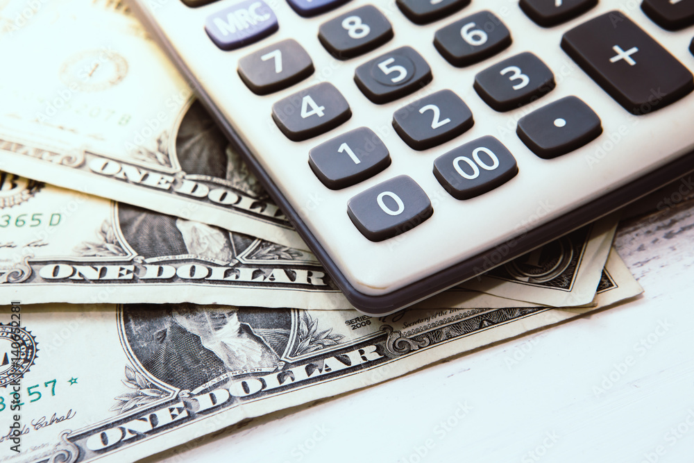 Calculator with american dollars on the wooden table background, finance concept Calculator with american dollars on the wooden table background, finance concept