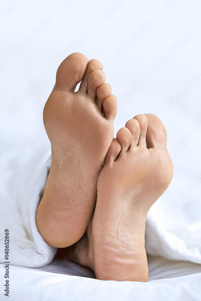 Person's foot in bed, close-up Person's foot in bed, close-up
