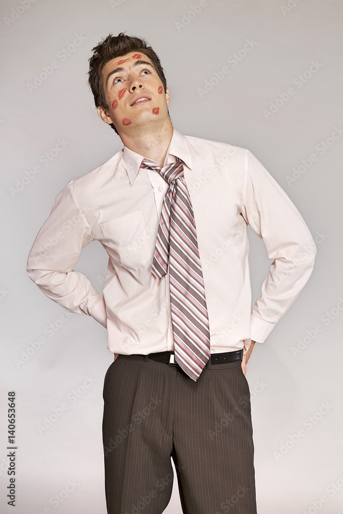 Young caucasian businessman with lipstick kiss mark on his cheek Young caucasian businessman with lipstick kiss mark on his cheek