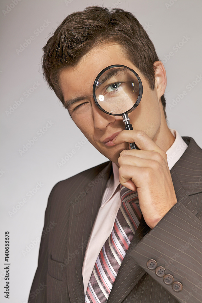 Young caucasian businessman with magnifying glass Young caucasian businessman with magnifying glass