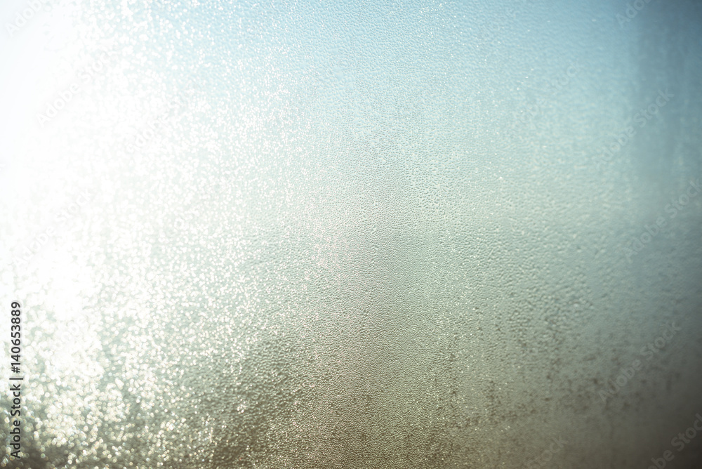 Sunny foggy window glass blurry condensation background, closeup image