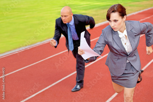 Businessman and woman on running on race track