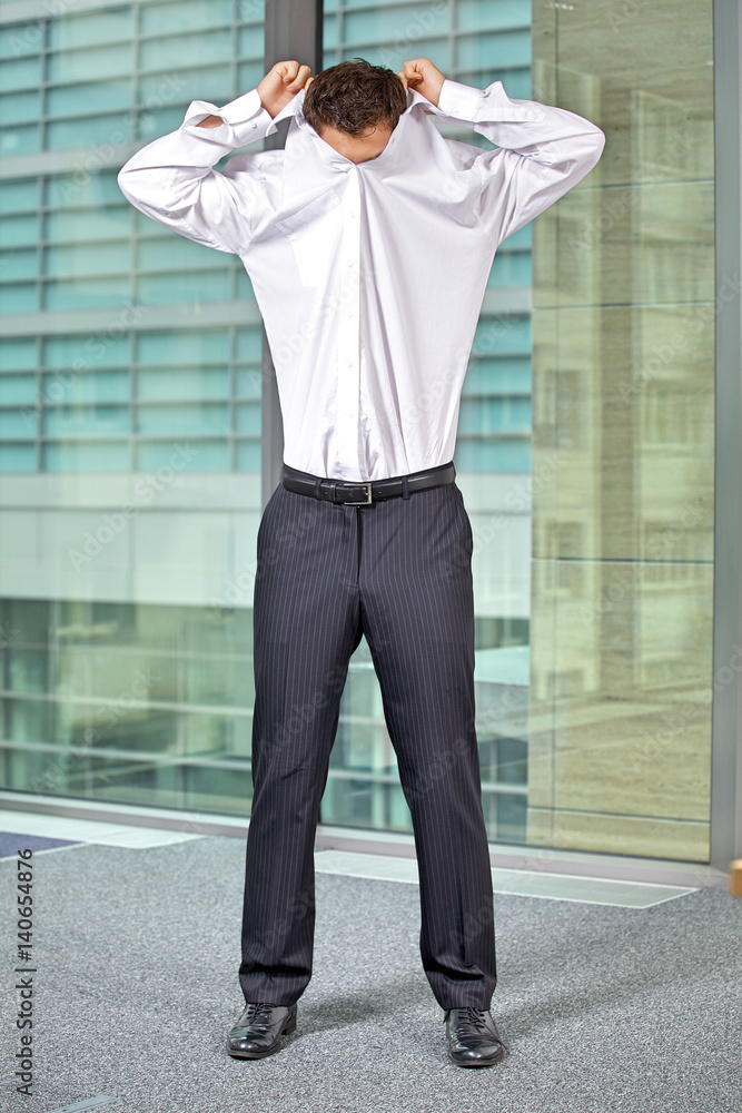 Businessman removing shirt at office Businessman removing shirt at office