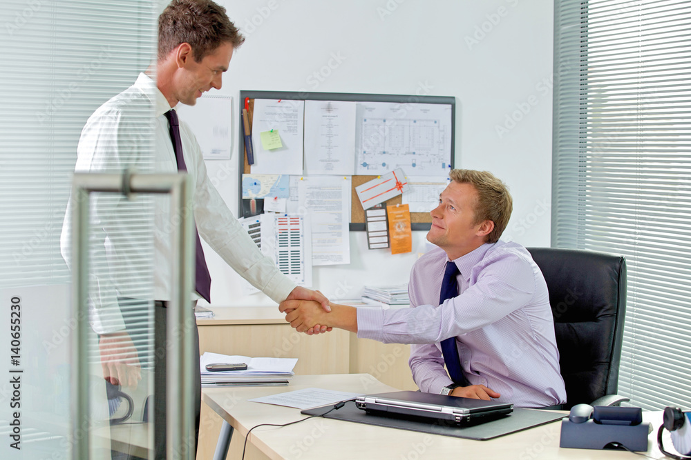 Two businessman shaking hands at office Two businessman shaking hands at office