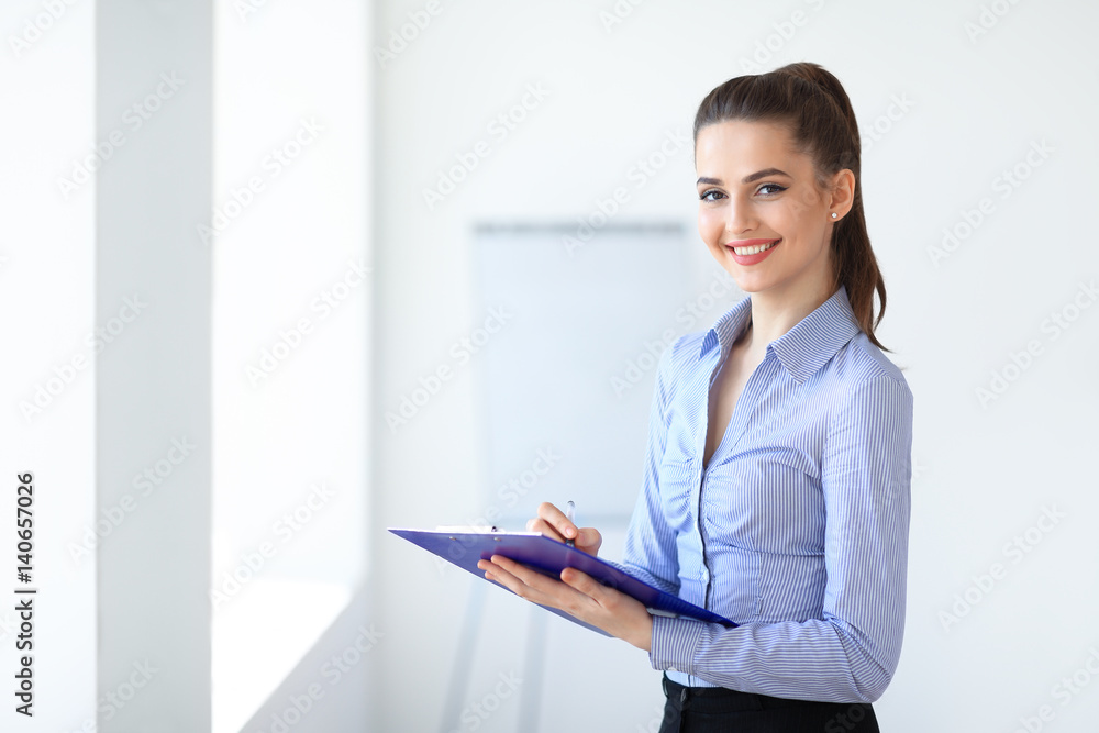 Happy beautiful business woman with clipboard in the office. Copy space Happy beautiful business woman with clipboard in the office. Copy space