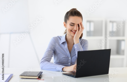 Surprised laughing business woman withvlaptop in the office