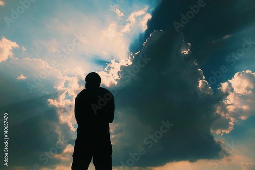 Silhouette of man and sky with sunlight
