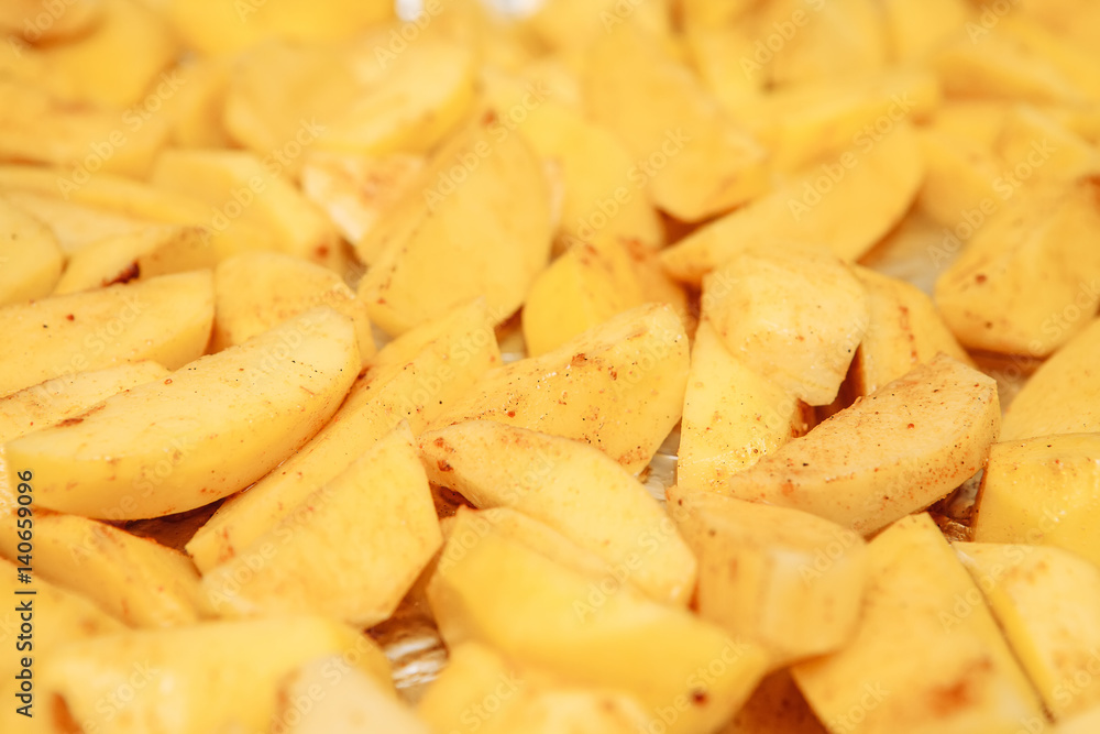 Raw potatoes slices on a baking sheet Raw potatoes slices on a baking sheet