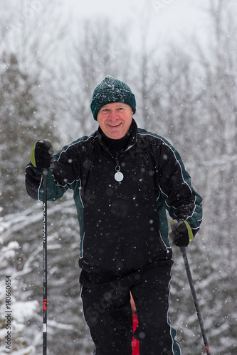 Obraz na płótnie senior in winter on snow with skis cross-country skiing w salonie