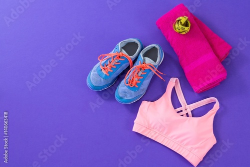 Sneakers, sports bra, towel and measuring tape