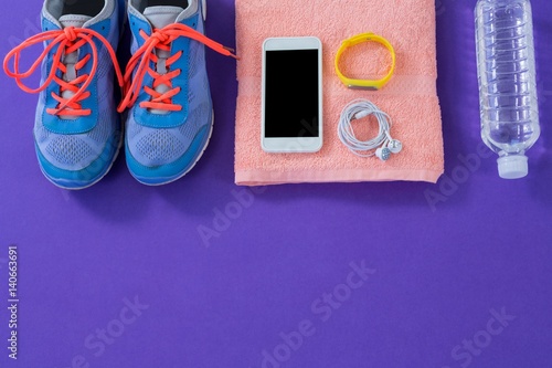 Sneakers, water , towel, phone with headphones