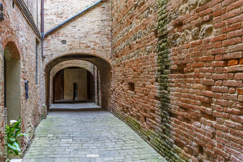 Alley with brick walls in an old village