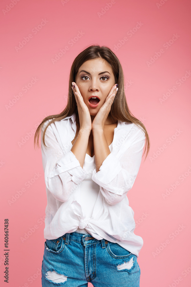 Pretty woman hold hands on cheeks and looks very surprised Pretty woman hold hands on cheeks and looks very surprised