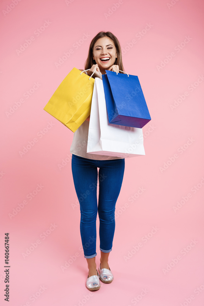 Woman in basic look holding bags after shopping at mall