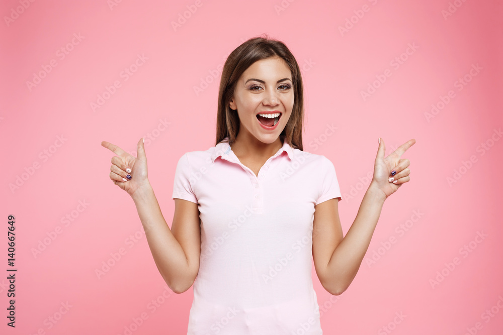 Young woman in sport look posing on light pink background 