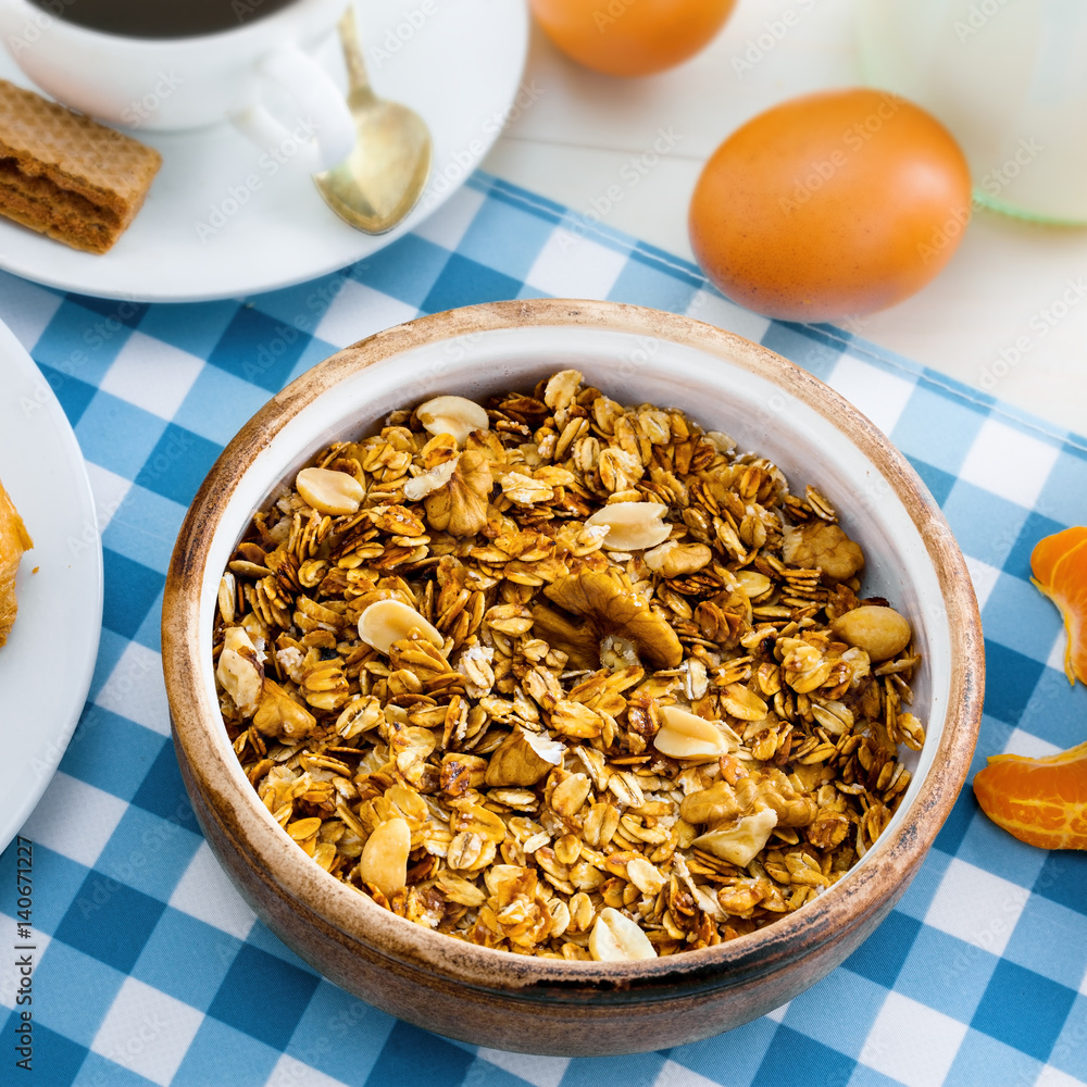 Oatmeal muesli with nuts, croissants, eggs, fruits, milk and coffee for delicious breakfast. Traditional healthy meal for breakfast on a table. Top view. Oatmeal muesli with nuts, croissants, eggs, fruits, milk and coffee for delicious breakfast. Traditional healthy meal for breakfast on a table. Top view.