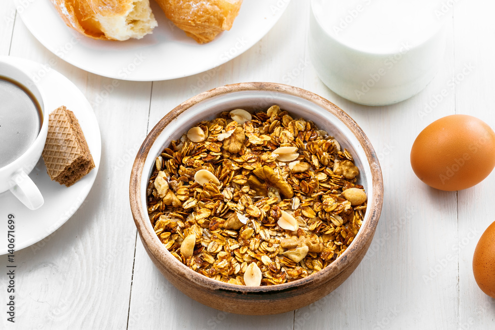 Granola, croissant, milk and fruits on a table. Healthy breakfast with coffee. International vegetarian meal. Top view. Granola, croissant, milk and fruits on a table. Healthy breakfast with coffee. International vegetarian meal. Top view.