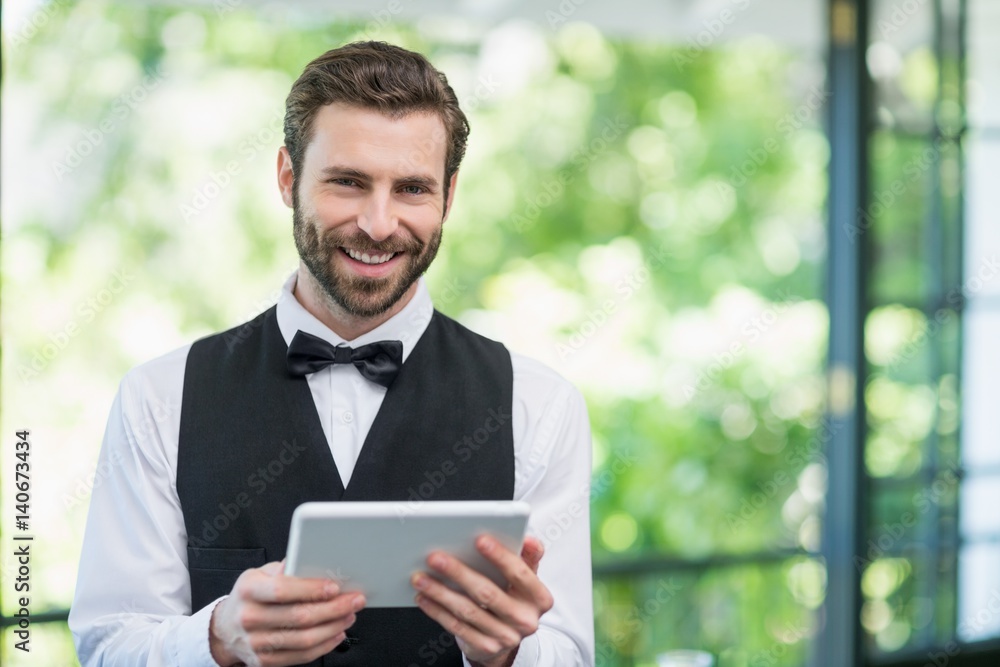 Male waiter holding digital tablet