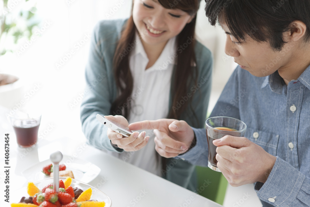 Young Couple Using Mobile Phone and Having Drink Young Couple Using Mobile Phone and Having Drink