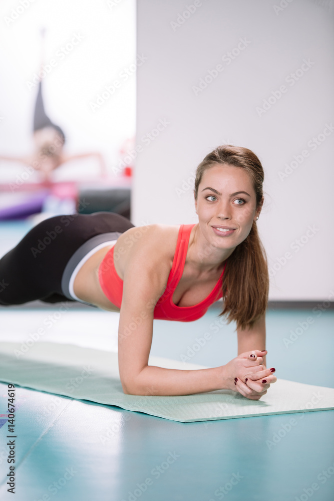 Sporty woman doing plank exercise in gym Sporty woman doing plank exercise in gym