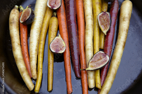 Tricolor carrots and figs in a cast iron pan.