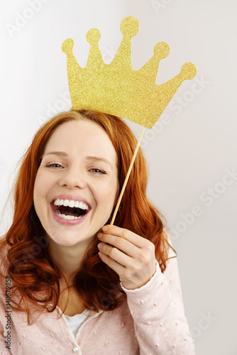 Fotografija lachende junge frau mit einer goldenen krone