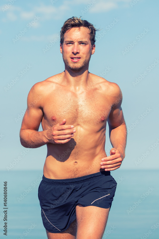 Foto Stock Handsome man fitness runner running topless in summer sunny day.  Athlete sexy sweating with muscular body and abs training outside. | Adobe  Stock