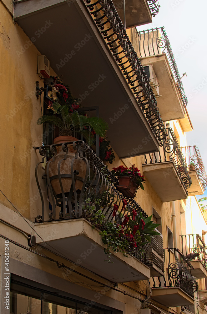 Small balcony beautifully decorated with various plants and flowers. Taormina. Sicily. Italy