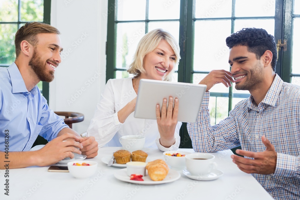 Executives using digital tablet in a restaurant Executives using digital tablet in a restaurant