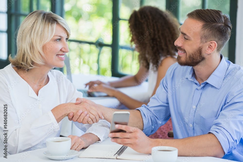 Obraz premium Executives shaking hands in a restaurant