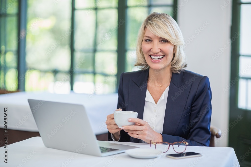Businesswoman holding coffee cup in a restaurant Businesswoman holding coffee cup in a restaurant