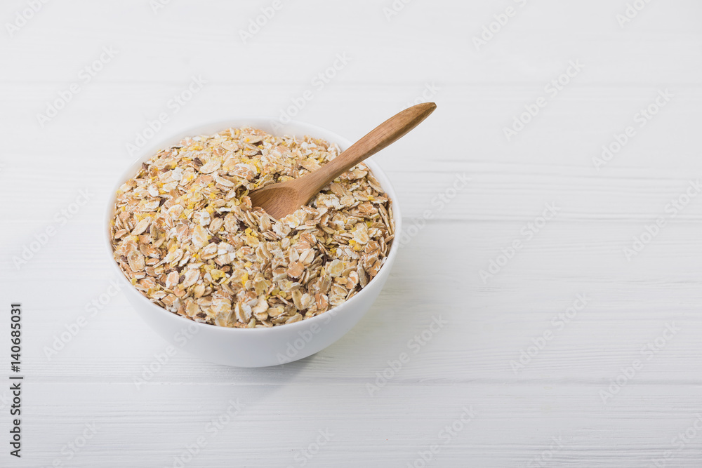 uncooked grain of oatmeal in white bowl uncooked grain of oatmeal in white bowl