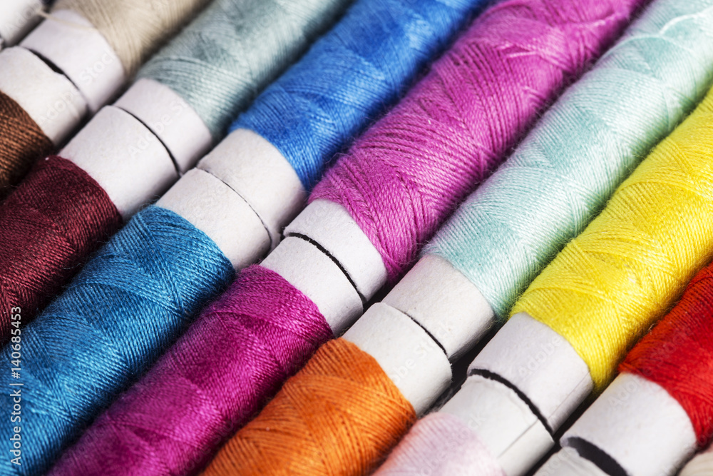 Multicolor sewing threads on wooden background Multicolor sewing threads on wooden background
