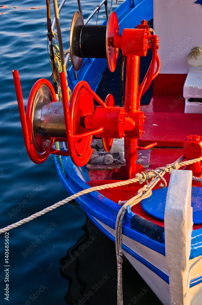 Detail of a fishing boat with red colorful machinery, Porto Koufo, Greece