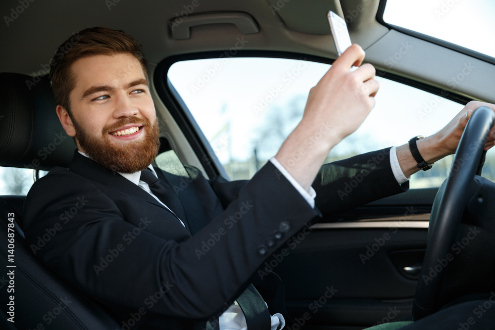 Side view of smiling business man making selfie