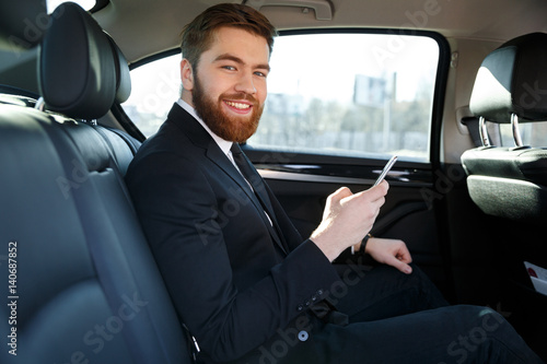 Side view of Smiling bearded business man in car © Drobot Dean