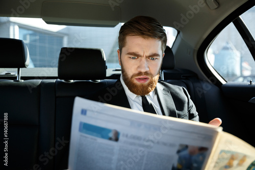 Incomprehensible business man reading newspaper
