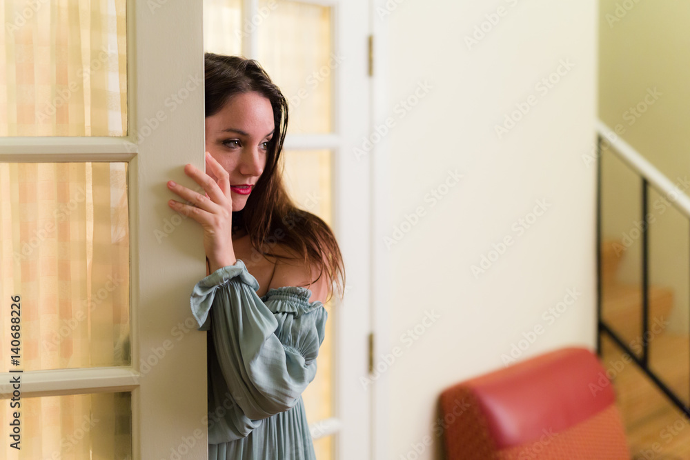 Middle aged caucasian woman in medieval dress and choker poses with a glass door