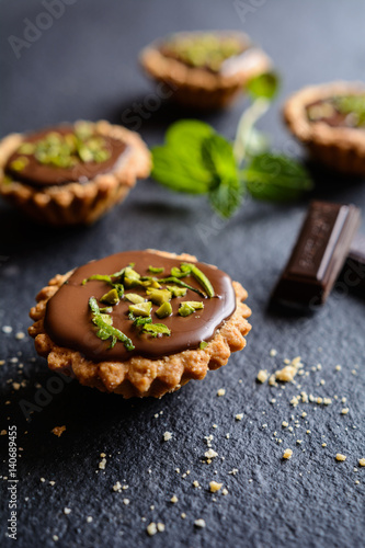 Tartlets with chocolate, pistachios and lime peel