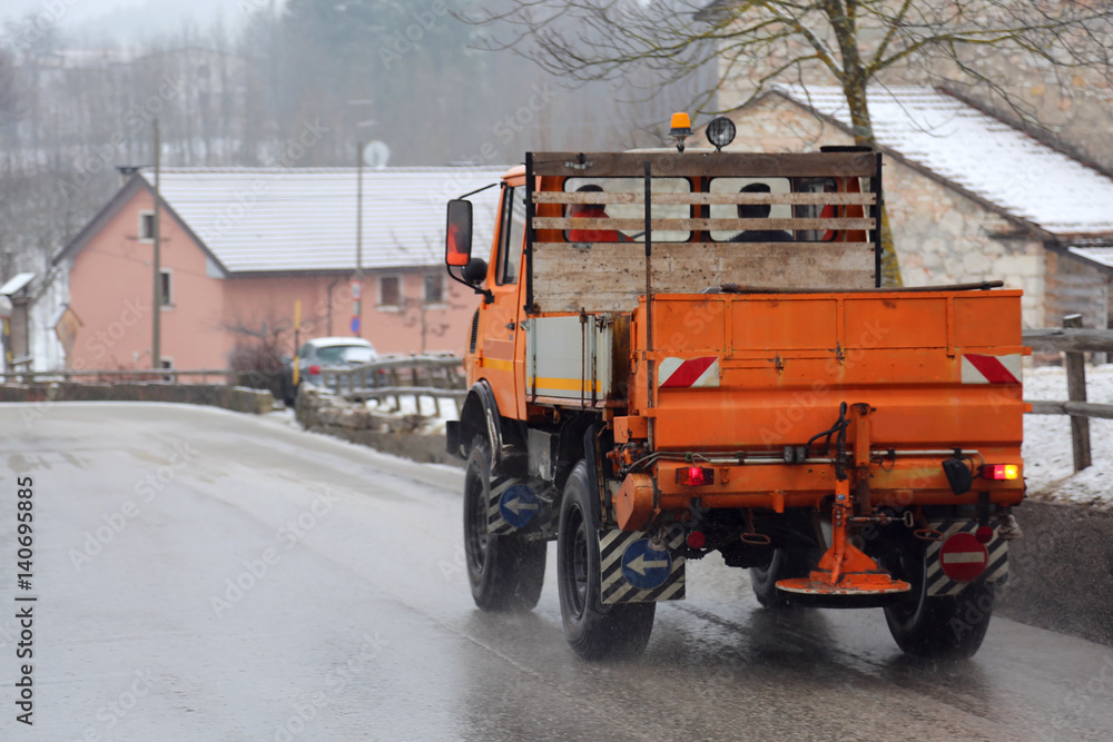 salt spreader on the road operating in winter salt spreader on the road operating in winter