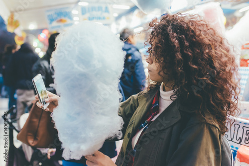 Young beautiful mixed race woman taking selfie holding cotton candy - technology, sharing, social network concept