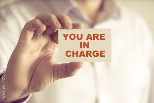 Businessman holding YOU ARE IN CHARGE message card photo